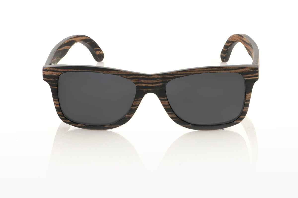 Wood eyewear of Ebony PARIS. PARIS wooden sunglasses feature a classic silhouette with a more square touch and a medium size, ideal for those looking for a timeless style with a perfect fit. This model is entirely made of African ebony wood, with an impressive grain in black and brown tones, which provides an air of sophistication. With measurements of 148x45 and a caliber of 54, the PARIS are perfect for those who value durability and design in their accessories. This pair is not only a complement to your outfit, but a statement of style and appreciation for natural details and quality craftsmanship. for Wholesale & Retail | Root Sunglasses® 